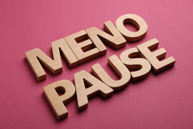 Photo of Word Menopause on crimson background, closeup view