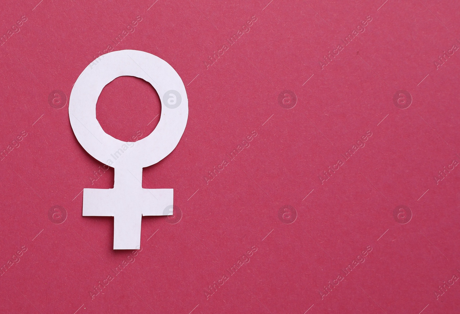 Photo of Menopause. Female gender symbol on crimson background, top view. Space for text