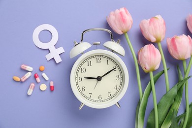 Photo of Menopause. Female gender symbol, pills, tulips and alarm clock on violet background, flat lay