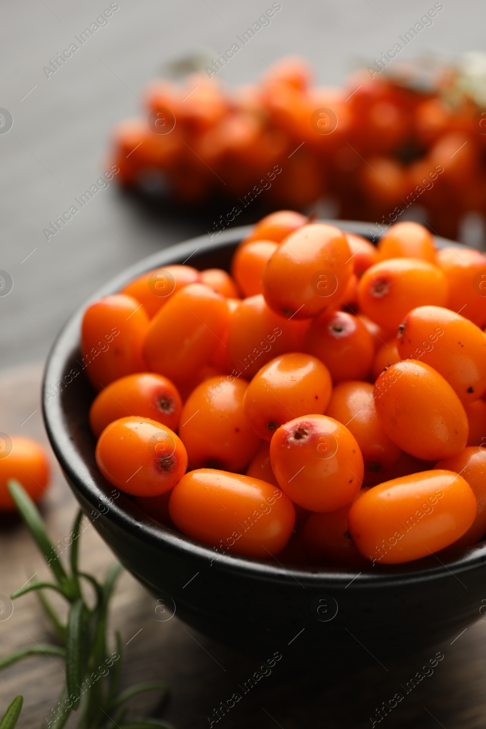 Photo of Fresh sea buckthorn berries with leaves on table, closeup