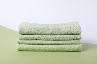 Photo of Stack of fresh terry towels on color background