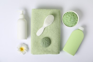 Photo of Fresh terry towel, cosmetic products, brush and plumeria flower on white background, flat lay
