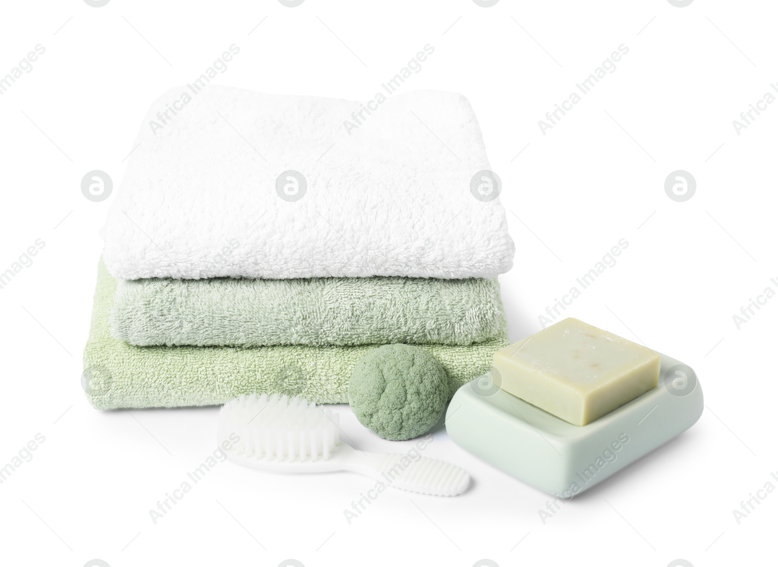Photo of Stack of fresh terry towels, cosmetic products and brush isolated on white