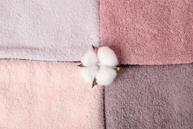 Photo of Fresh terry towels and plumeria flower as background, top view