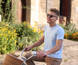 Photo of Happy man in sunglasses riding bicycle on city street