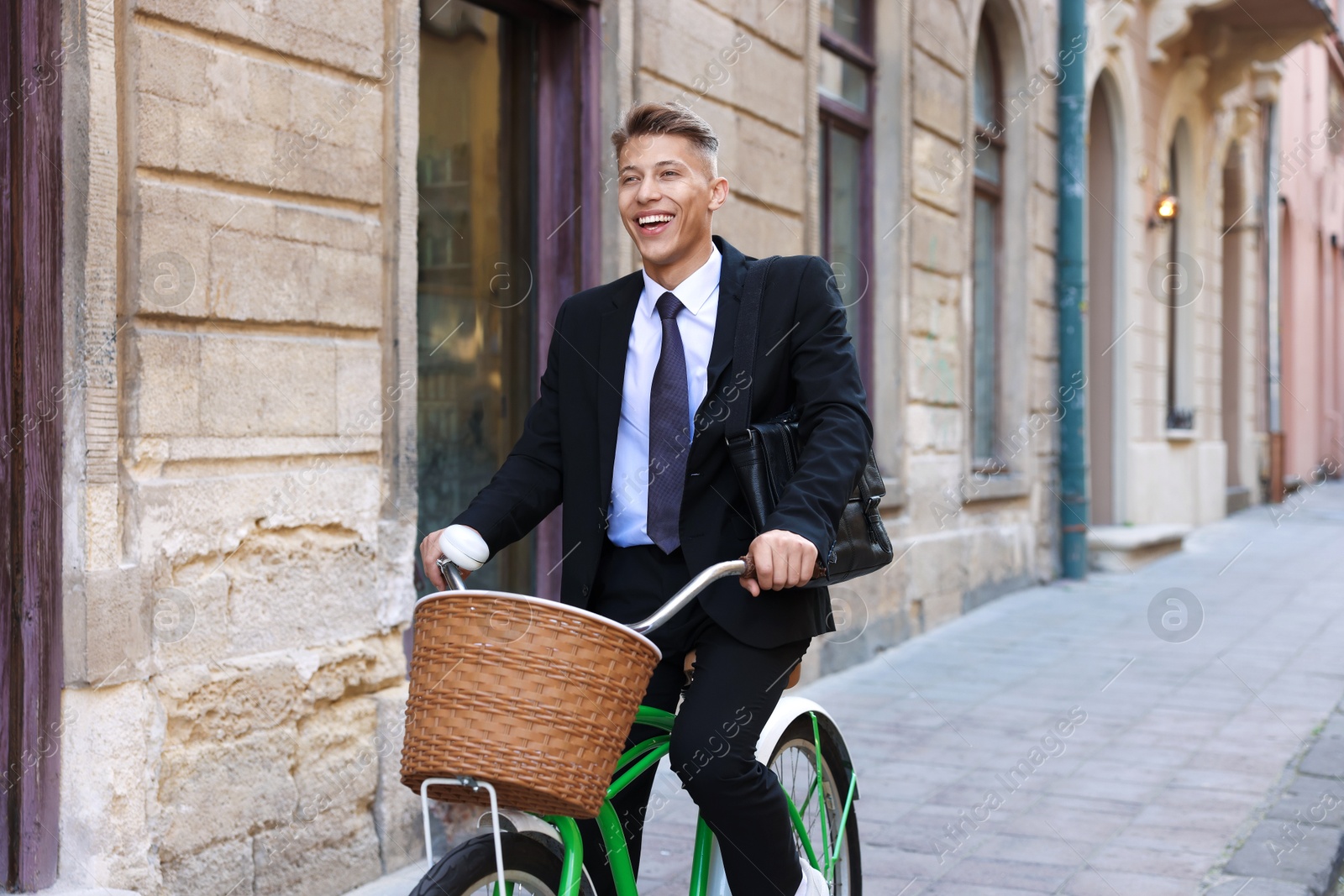 Photo of Man in suit riding bicycle on city street