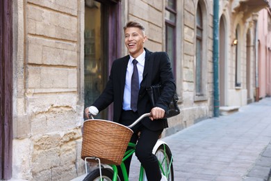 Photo of Man in suit riding bicycle on city street