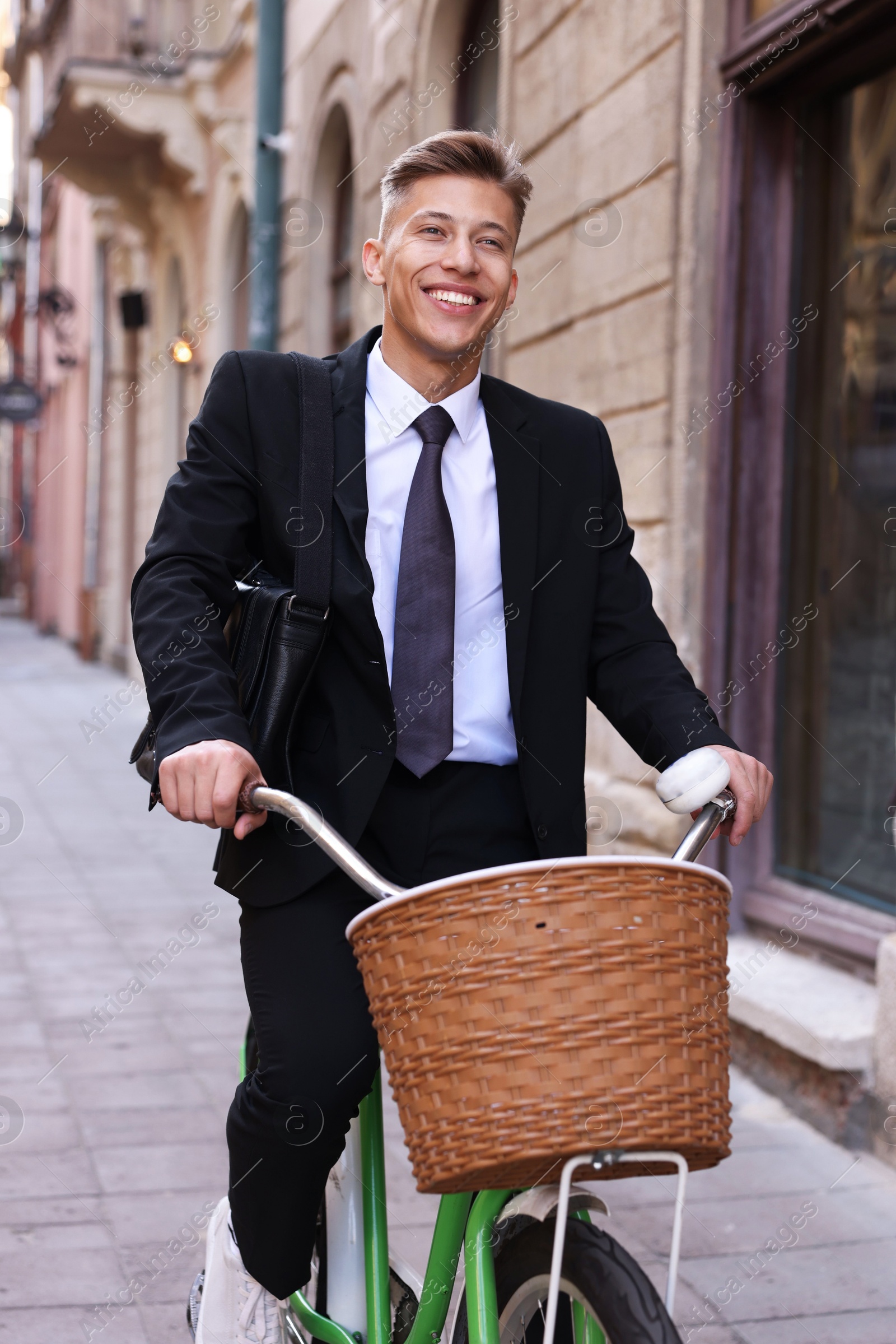 Photo of Man in suit riding bicycle on city street