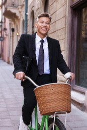 Photo of Man in suit riding bicycle on city street