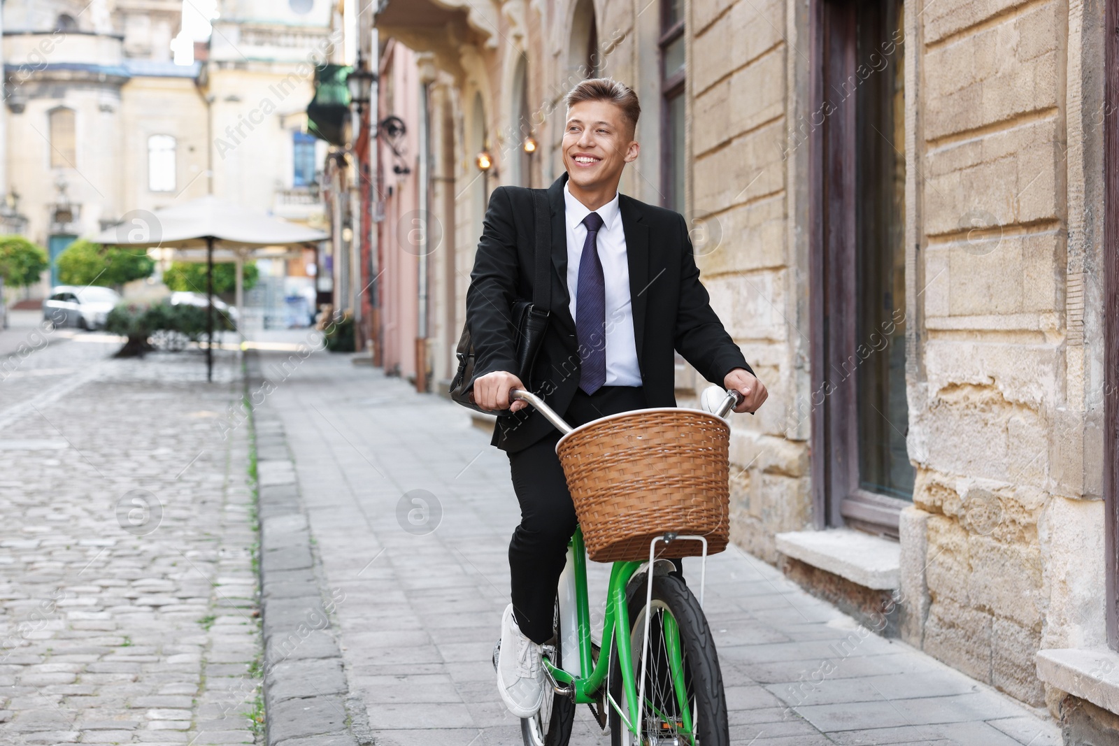 Photo of Man in suit riding bicycle on city street