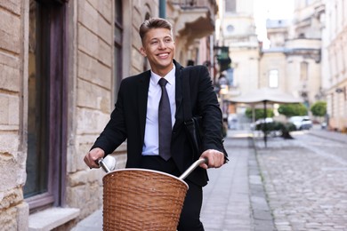 Photo of Man in suit riding bicycle on city street