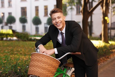 Photo of Man in suit riding bicycle on city street