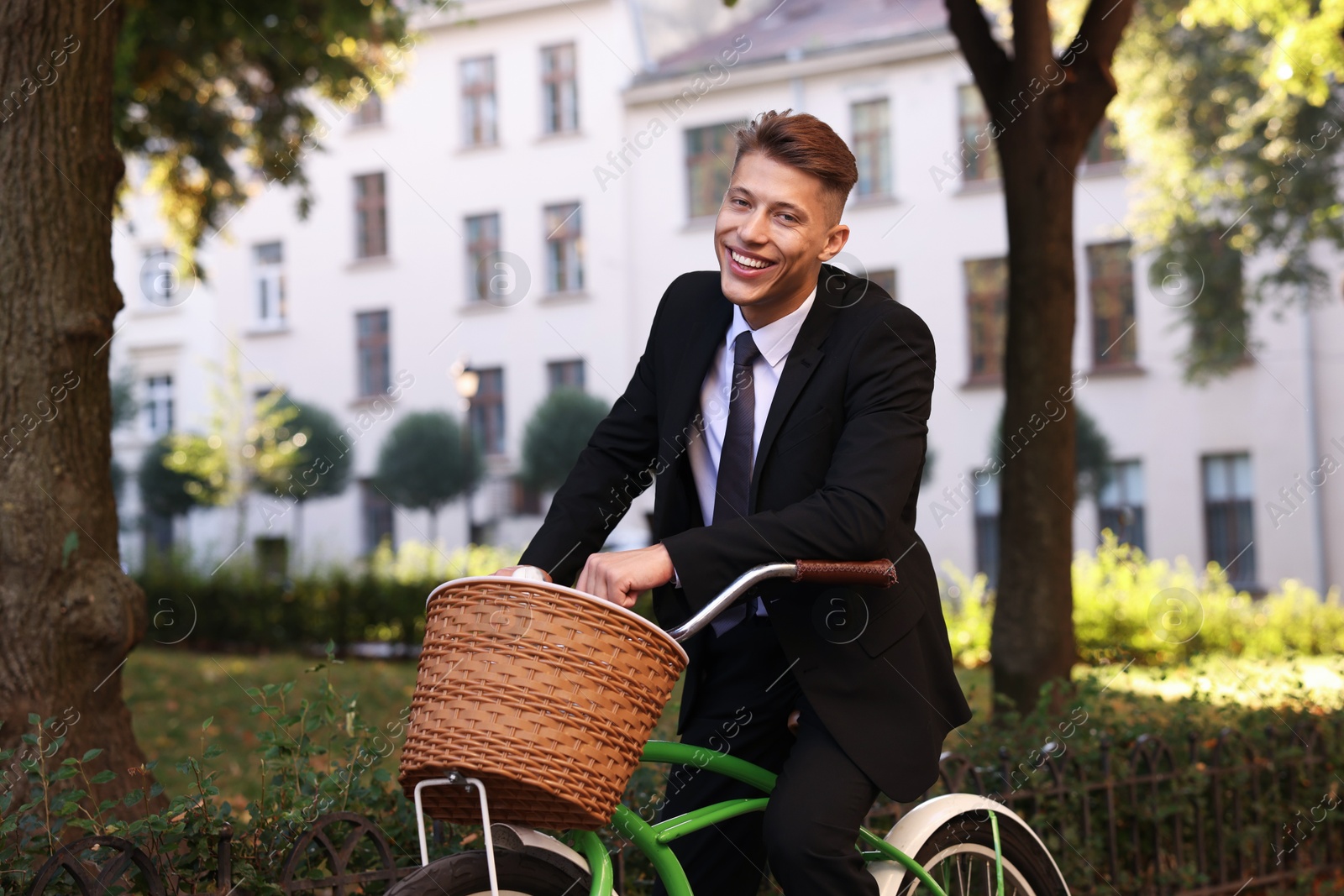 Photo of Man in suit riding bicycle on city street
