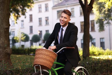 Photo of Man in suit riding bicycle on city street