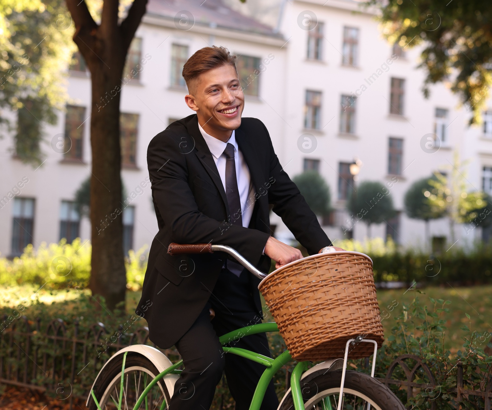 Photo of Man in suit riding bicycle on city street