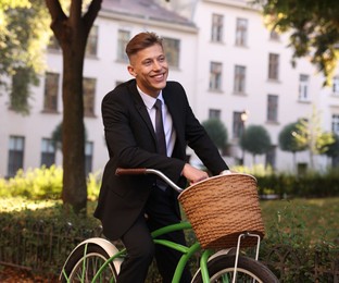 Photo of Man in suit riding bicycle on city street