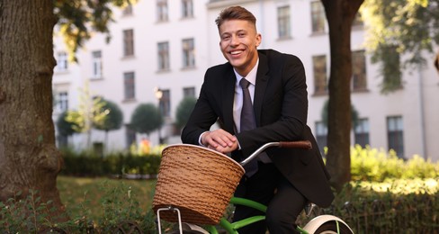 Photo of Man in suit riding bicycle on city street