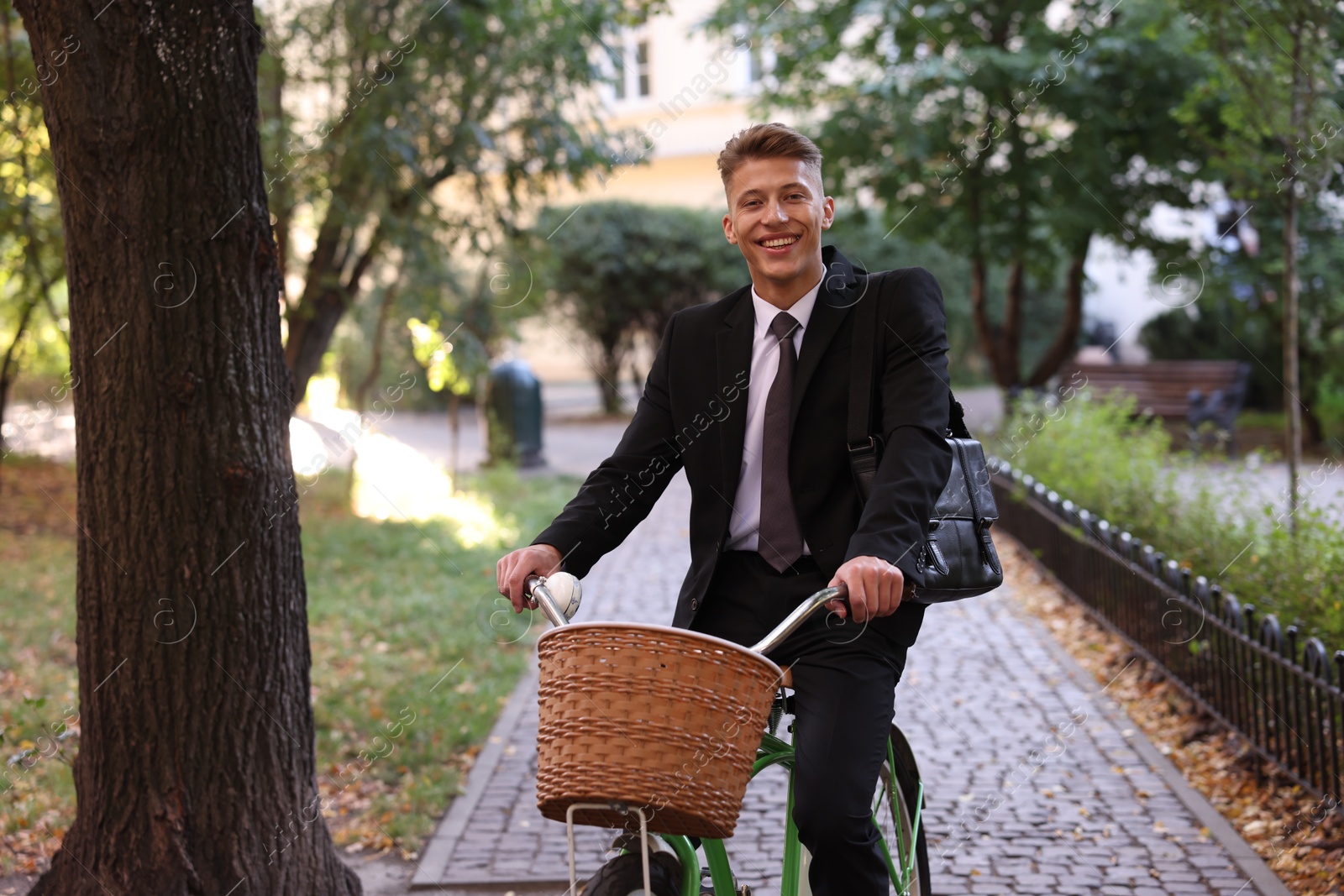 Photo of Man in suit riding bicycle on city street