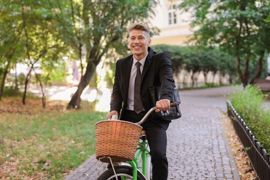 Photo of Man in suit riding bicycle on city street