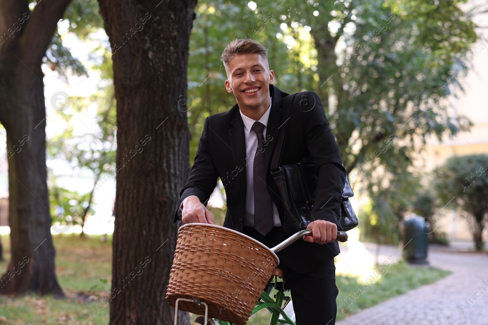 Photo of Man in suit riding bicycle on city street