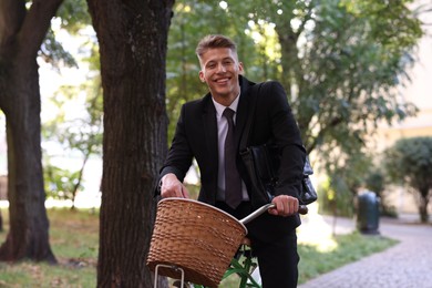 Photo of Man in suit riding bicycle on city street