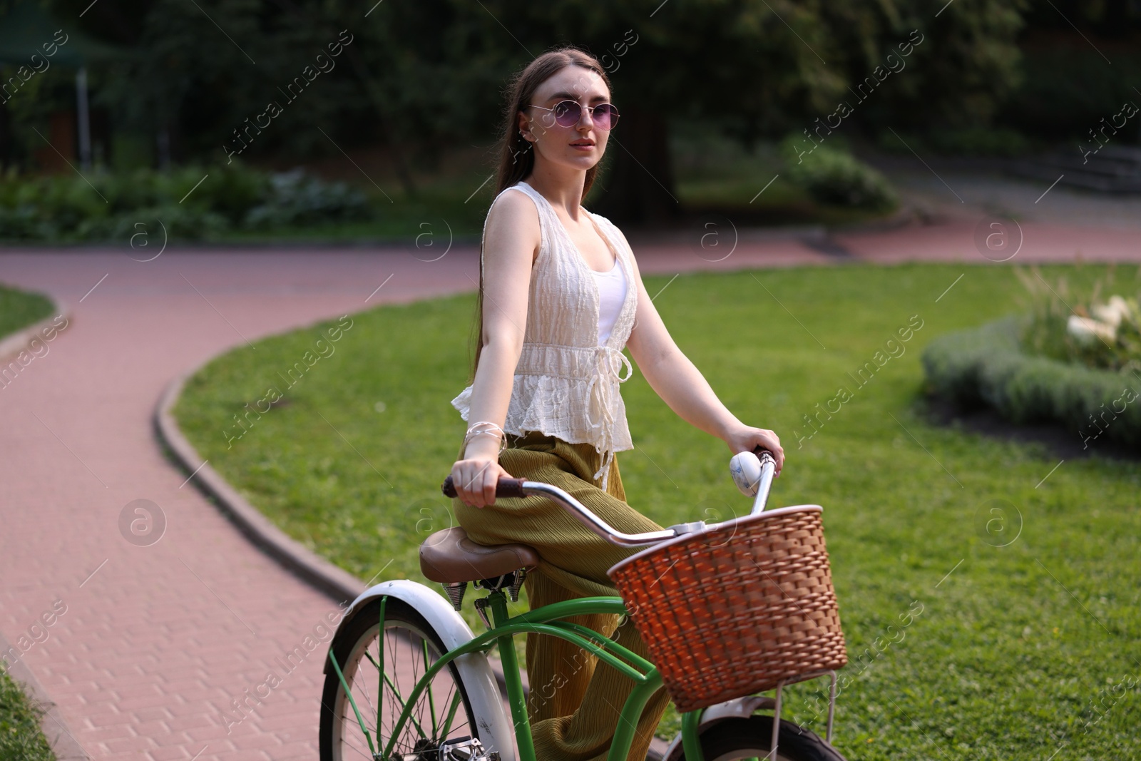 Photo of Happy woman riding her bicycle in park