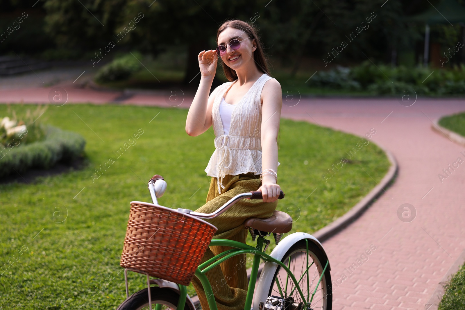 Photo of Happy woman riding her bicycle in park