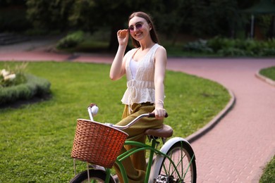 Photo of Happy woman riding her bicycle in park