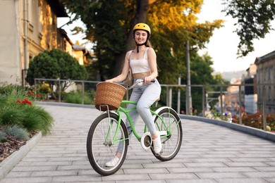 Photo of Woman in helmet riding bicycle on city street