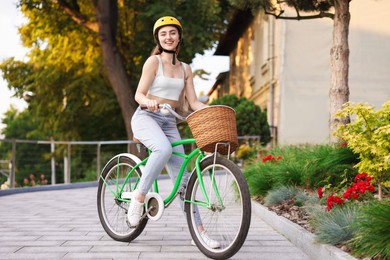 Photo of Woman in helmet riding bicycle on city street