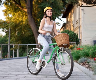 Photo of Woman in helmet riding bicycle on city street