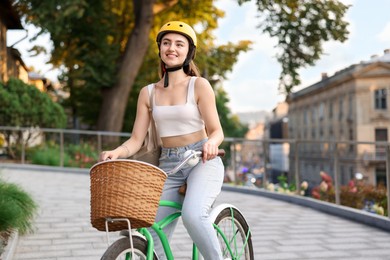 Photo of Woman in helmet riding bicycle on city street