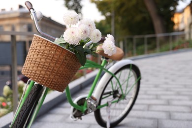 Photo of Bicycle with beautiful flowers in basket on city street