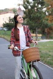 Photo of Beautiful woman listening to music while riding bicycle in park