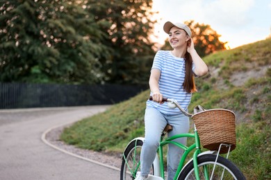 Photo of Happy woman riding bicycle on city street. Space for text