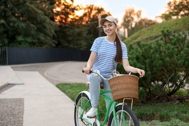 Photo of Happy woman riding bicycle on city street. Space for text