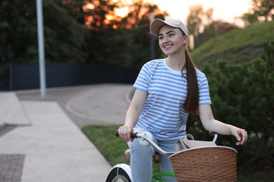 Photo of Happy woman riding bicycle on city street. Space for text