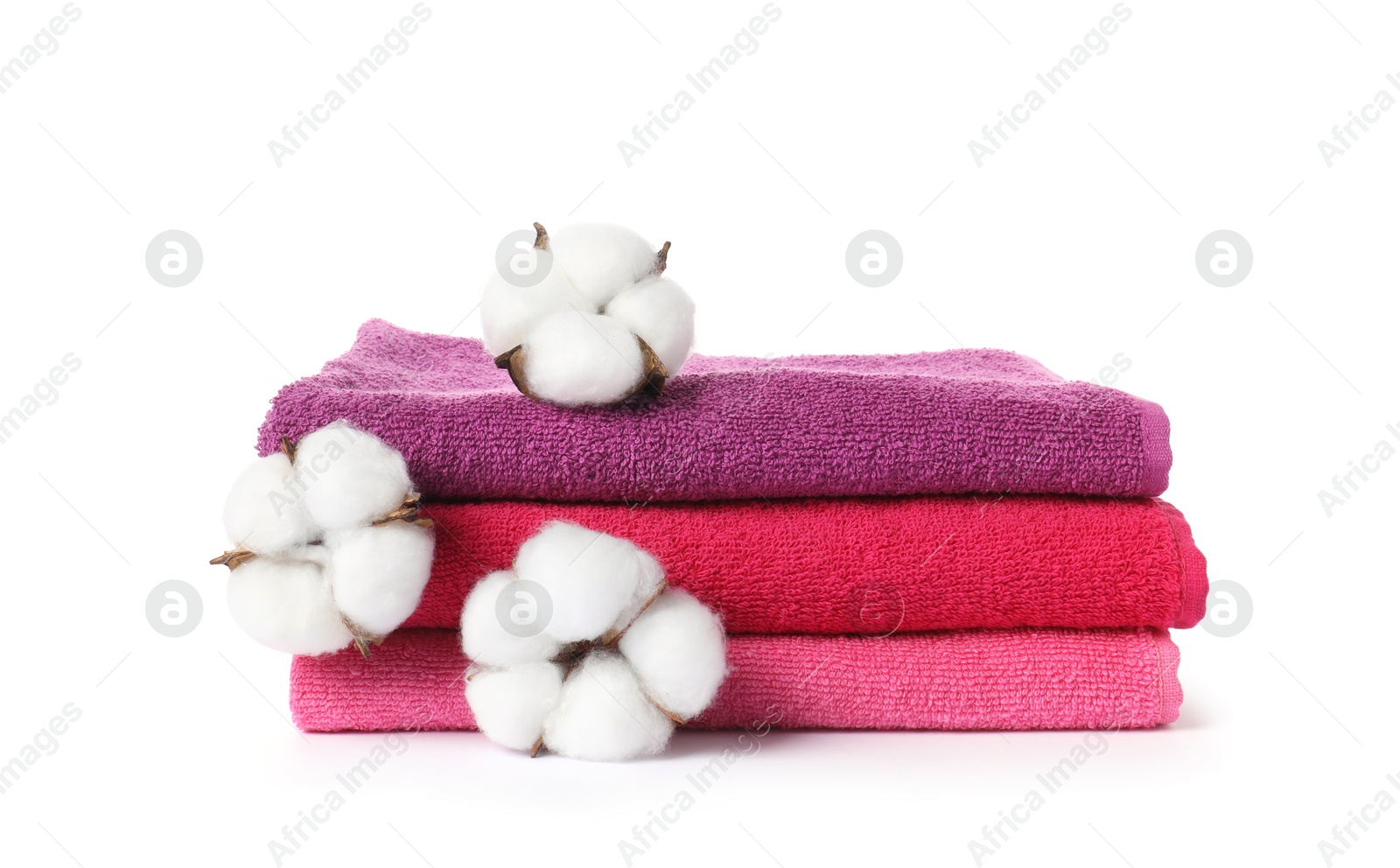 Photo of Stack of fresh terry towels and cotton flowers isolated on white