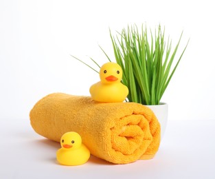 Photo of Rolled fresh terry towel, rubber ducks and floral decor isolated on white