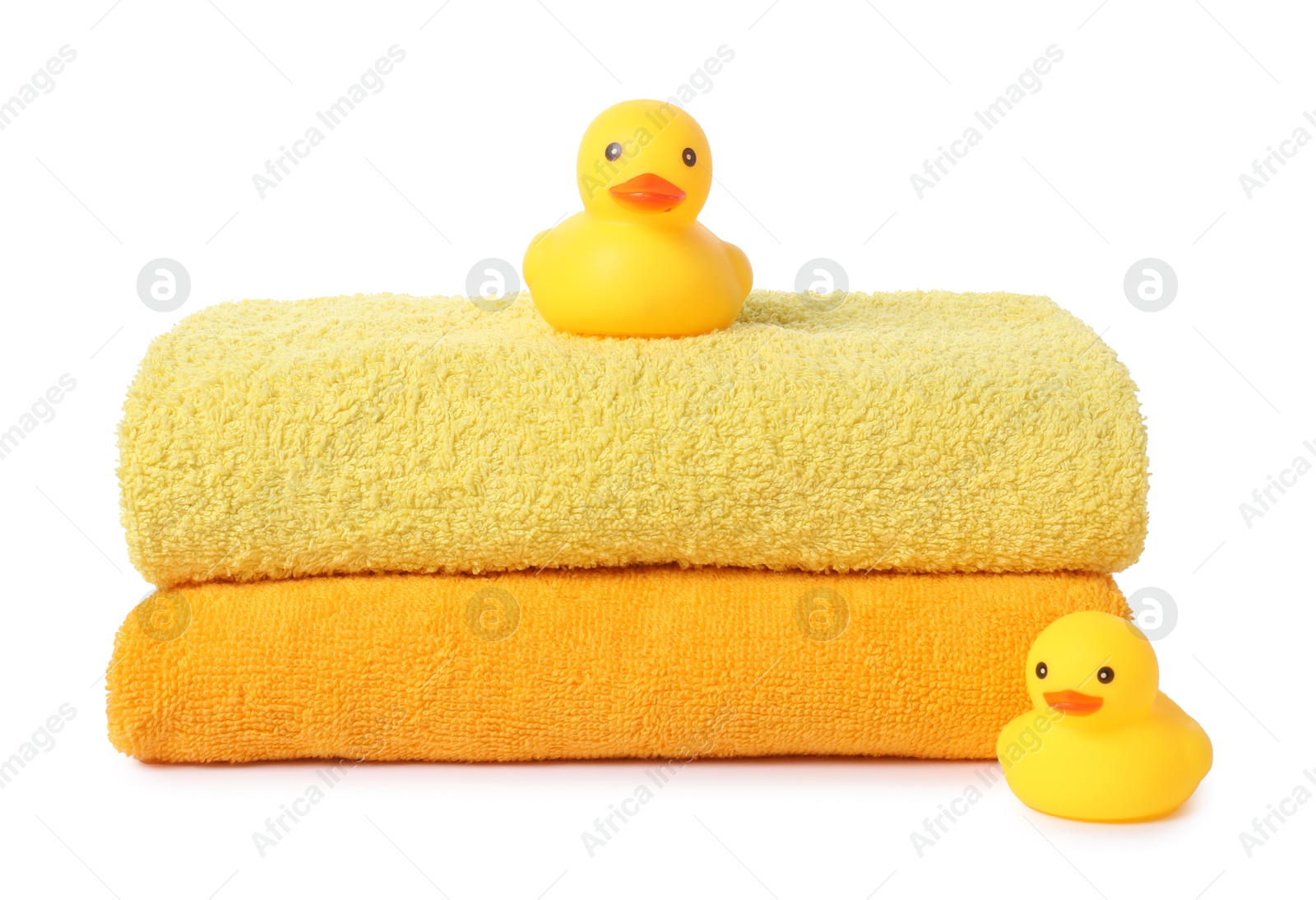 Photo of Stack of fresh terry towels and rubber ducks isolated on white