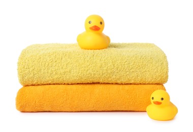 Photo of Stack of fresh terry towels and rubber ducks isolated on white