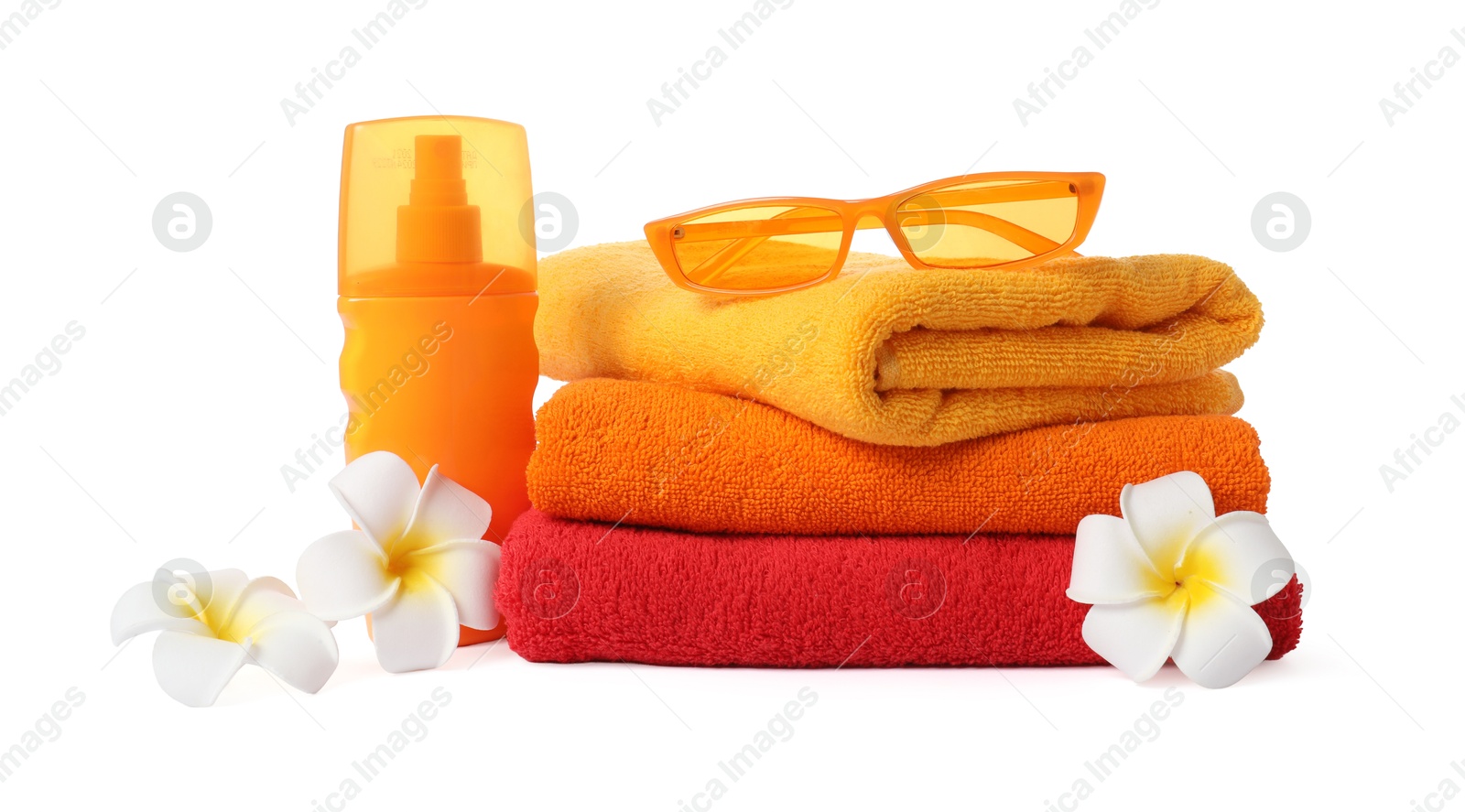 Photo of Fresh terry towels, cosmetic product, sunglasses and plumeria flowers isolated on white