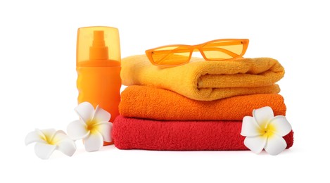 Photo of Fresh terry towels, cosmetic product, sunglasses and plumeria flowers isolated on white