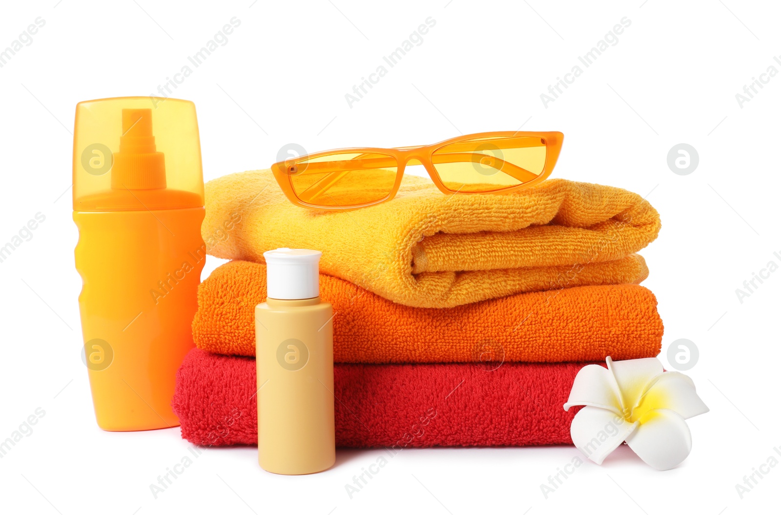 Photo of Fresh terry towels, cosmetic products, sunglasses and plumeria flower isolated on white