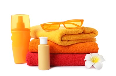 Photo of Fresh terry towels, cosmetic products, sunglasses and plumeria flower isolated on white