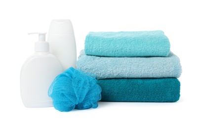 Photo of Stack of fresh terry towels, cosmetic products and sponge isolated on white