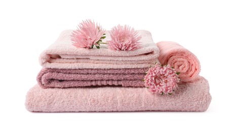 Photo of Stack of fresh terry towels and flowers isolated on white