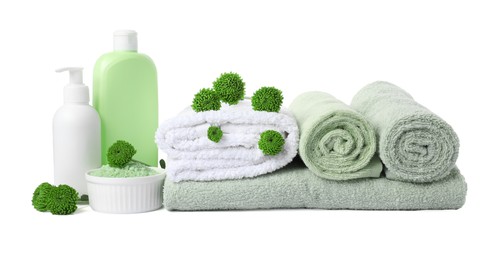 Photo of Fresh terry towels, cosmetic products and green flowers isolated on white