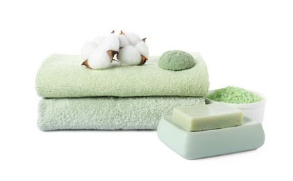 Photo of Stack of fresh terry towels, cosmetic products, cotton flowers and sponge isolated on white