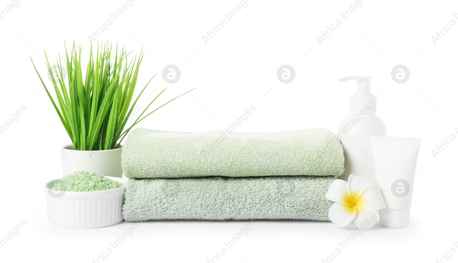 Photo of Stack of fresh terry towels, cosmetic products and floral decor isolated on white